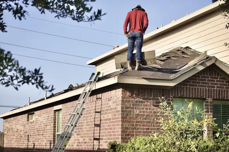 Professional roofer working on a residential roof in Manchester Meadows